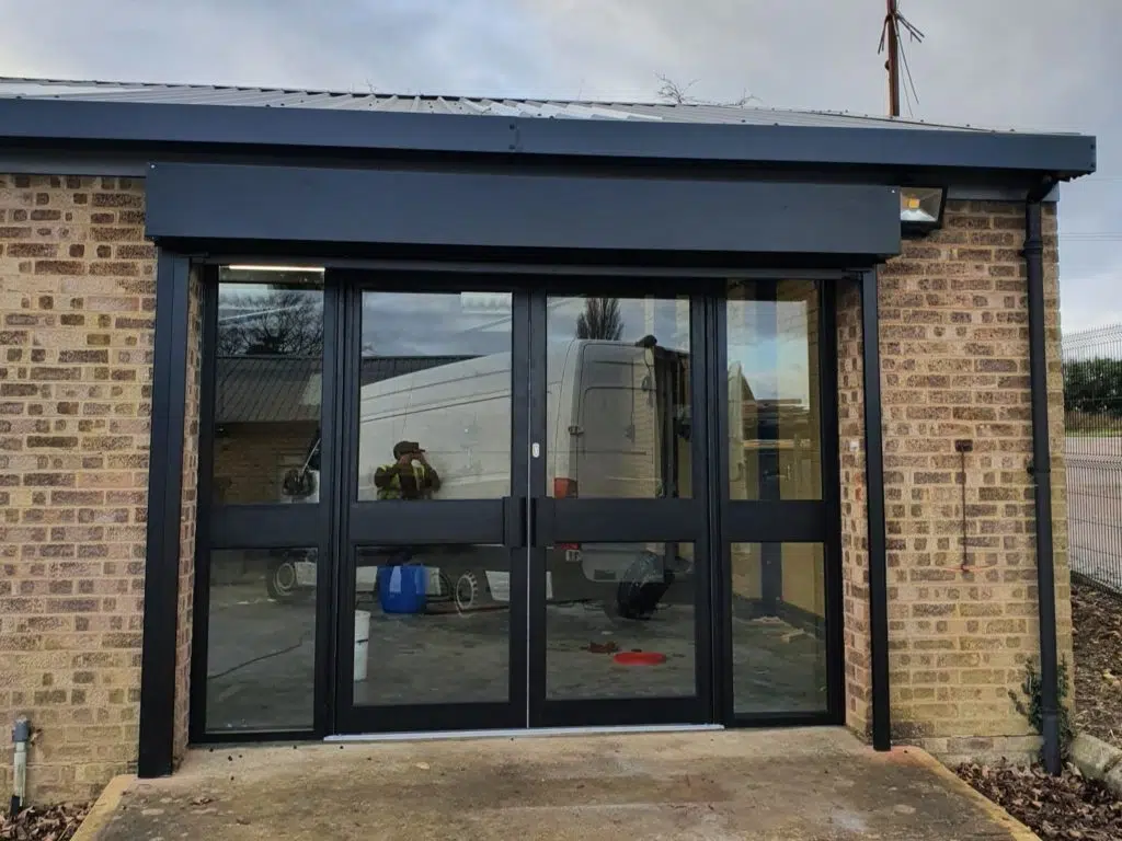 Double glass and aluminium doors with pad handles and glass side panels